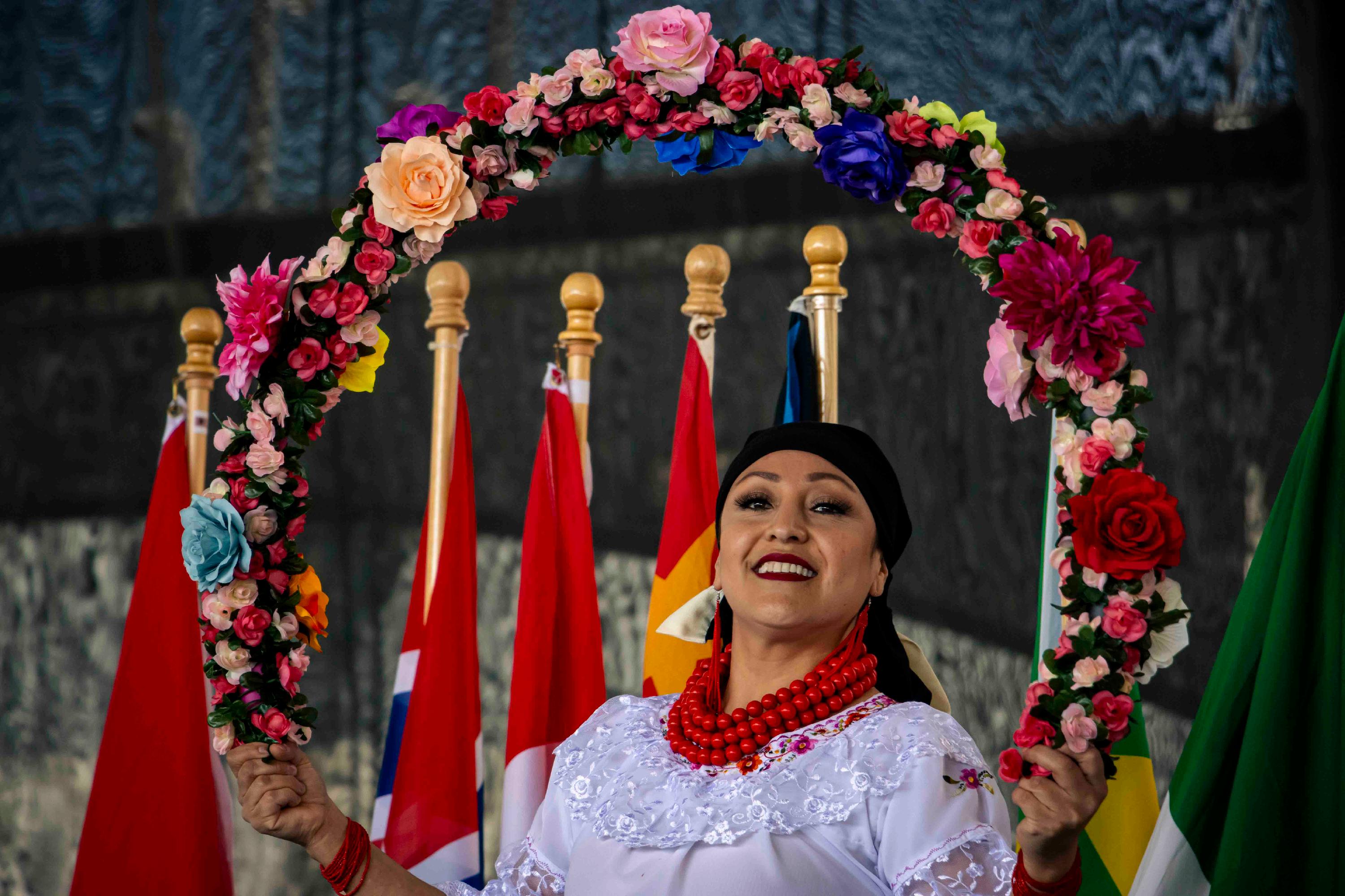 A member of the Ecuadorian Society holds a floral wreath at Worldfest 2022